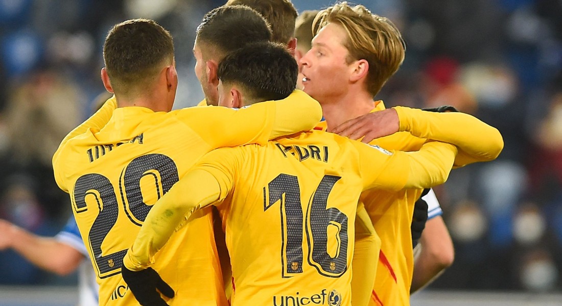 Barcelona's Dutch midfielder Frenkie De Jong (R) celebrates with teammates after scoring a goal during the Spanish league football match between Deportivo Alaves and FC Barcelona at the Mendizorroza stadium in Vitoria on January 23, 2022. (Photo by Ander GILLENEA / AFP)