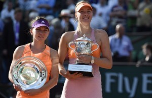 Russia's Maria Sharapova (R) holds the Suzane Lenglen trophy and Romania's Simona Halep holds the runner up trophy after the French tennis Open final match against at the Roland Garros stadium in Paris on June 7, 2014. 