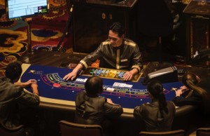 Employees sit at gaming tables ahead of opening at Studio City casino resort, developed by Melco Crown Entertainment Ltd., in Macau, China, on Monday, Oct. 26, 2015. Melco Crown is touting a Batman ride, Asia’s highest ferris wheel and other Hollywood-centric features for Studio City which is scheduled to open on Oct. 27. Photographer: Xaume Olleros/Bloomberg